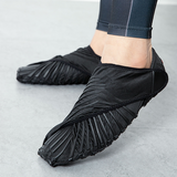 Ein Paar schwarze Yogas-Schuhe der Marke ShopYoga. Diese können als alternative zu Yoga Socken getragen werden.